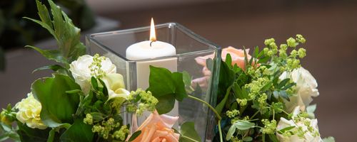 Blumenarrangement mit Kerze bei der Schäfer & Co. Bestattungsgesellschaft